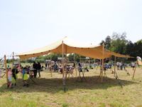 Stijlvolle feesttent met beige stretchdoek en houten palen